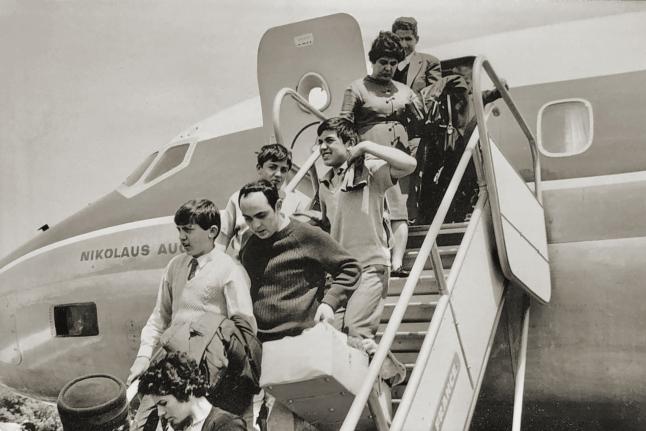 A group of people are disembarking from an aeroplane