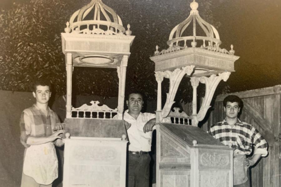 Emmanuel Dimitriades with his father Christos (centre) and brother George  (left) after completing pieces of church furniture, standing outside their workshop in Kensington c.1962