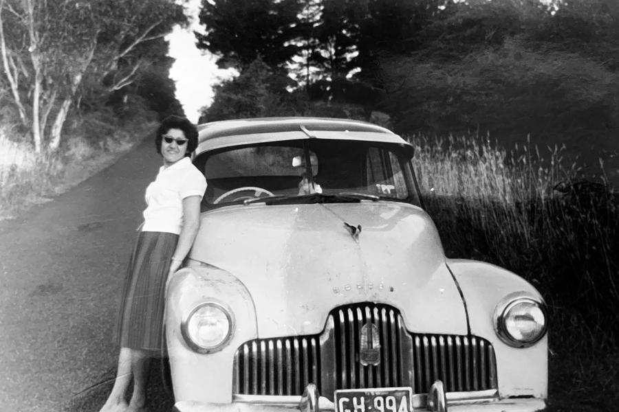 A person is leaning on the bonnet of a car