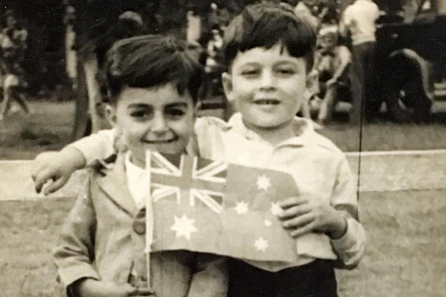Two smiling children holding an Australian flag
