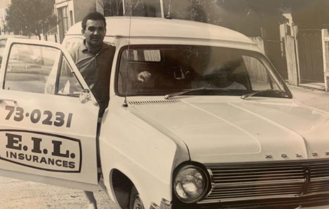 a man stands beside a taxi with the door open