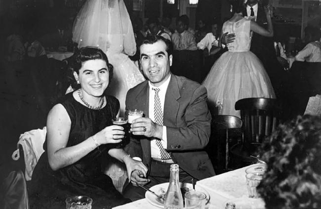 Two smiling people are having a drink 