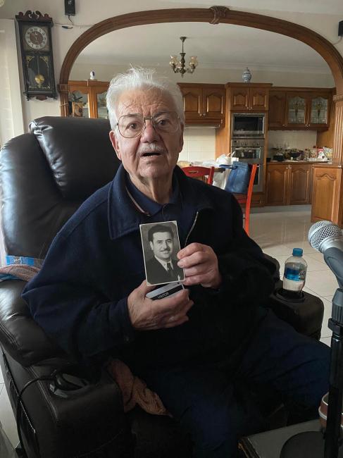 Emmanuel Dimitriades holding a photograph of his father, Christos Dimitriadis