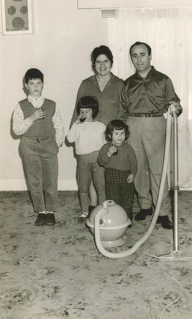 Family standing in a lounge room. 