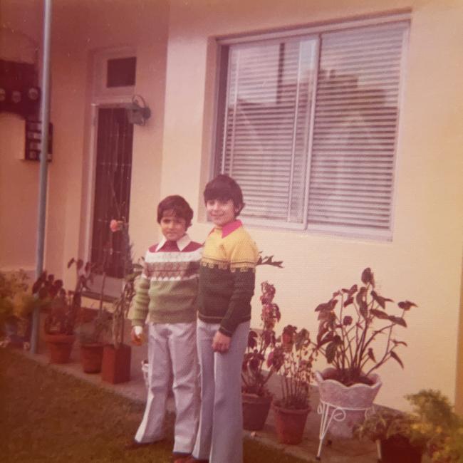 Two boys standing outside a house