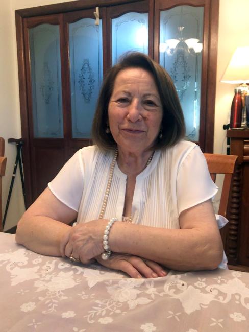 A smiling person sitting at a table