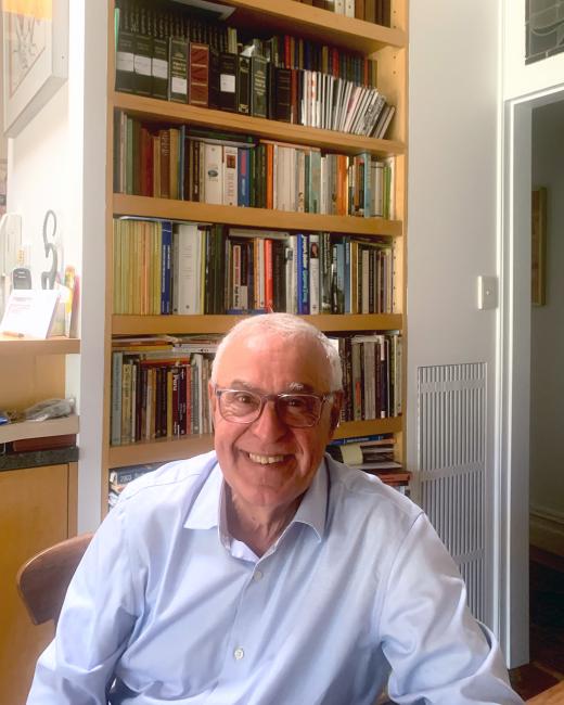 A person sitting in front of a bookshelf