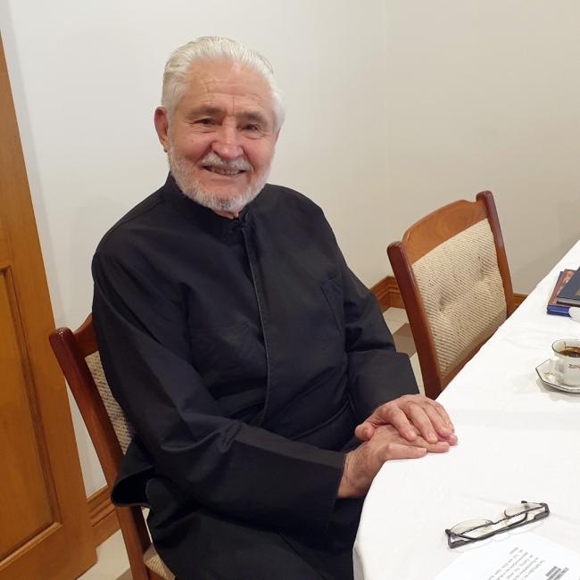 A smiling person sitting at table