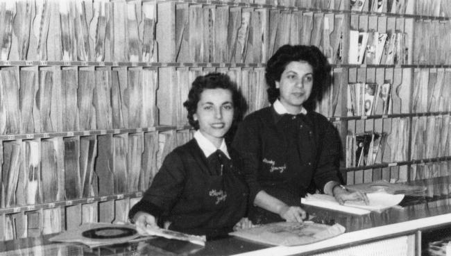 Two people working at a record counter