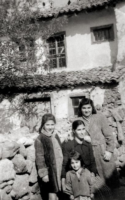 A group of people sit outside a house